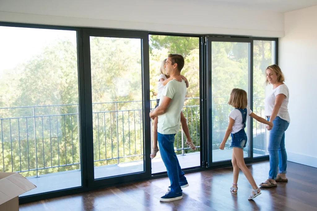 happy father with daughter standing near open balcony smiling